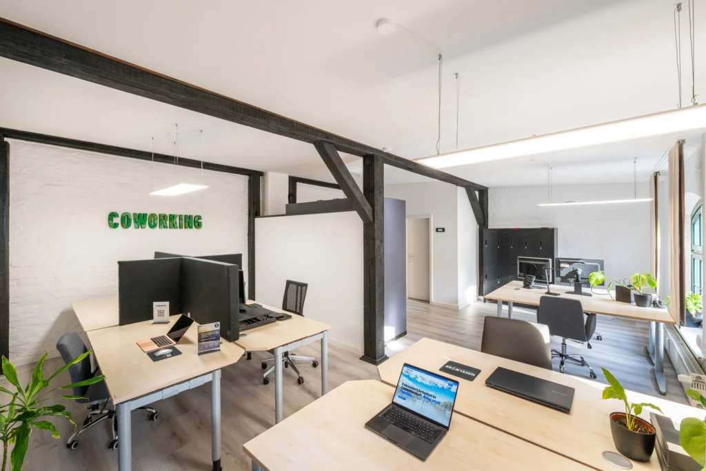 Open Space mit Coworking-Arbeitsplätzen unter Fachwerkbalken